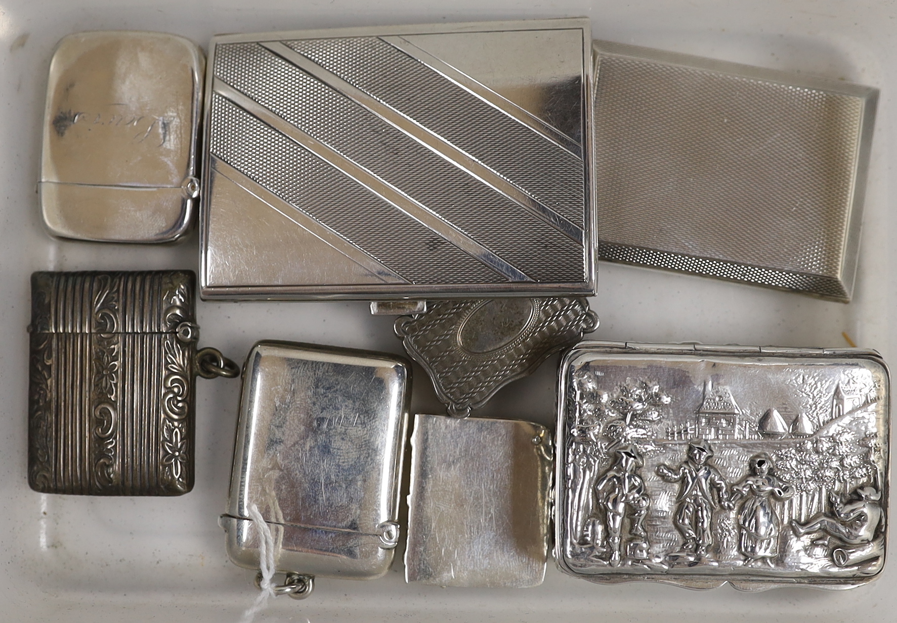 A Victorian engine turned silver vinaigrette, Birmingham, 1876, 33mm, three assorted later silver vesta cases, a small repousse silver box and cover, a silver match case, German 835 cigarette case and a metal stamp case.